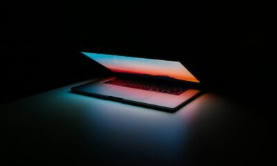 Notebook com tela iluminada em ambiente escuro.