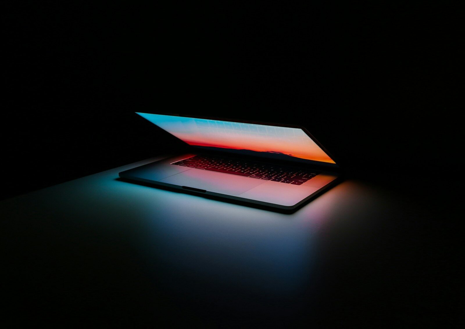 Notebook com tela iluminada em ambiente escuro.