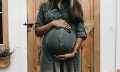 Mulher grávida segurando sua barriga em ambiente acolhedor.