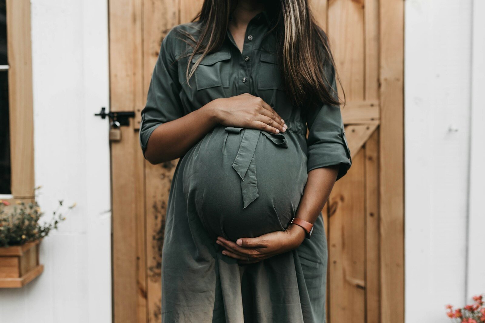 Mulher grávida segurando sua barriga em ambiente acolhedor.