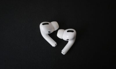 Fones de ouvido sem fio brancos sobre fundo preto, tecnologia de áudio portátil.