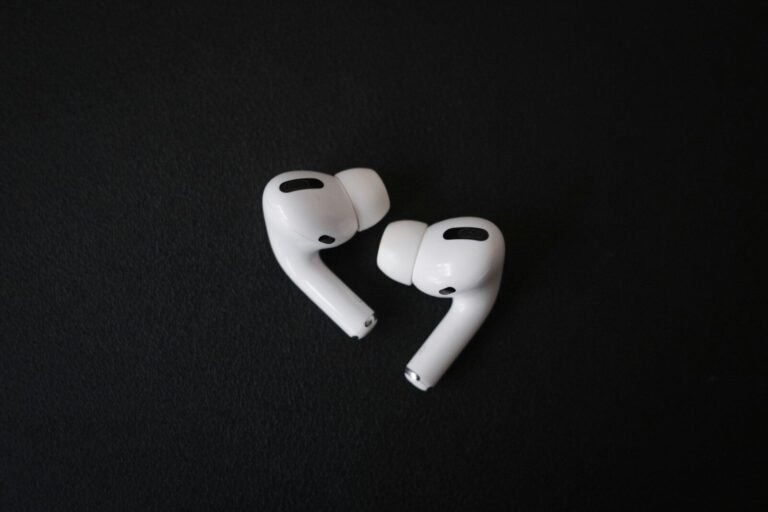 Fones de ouvido sem fio brancos sobre fundo preto, tecnologia de áudio portátil.