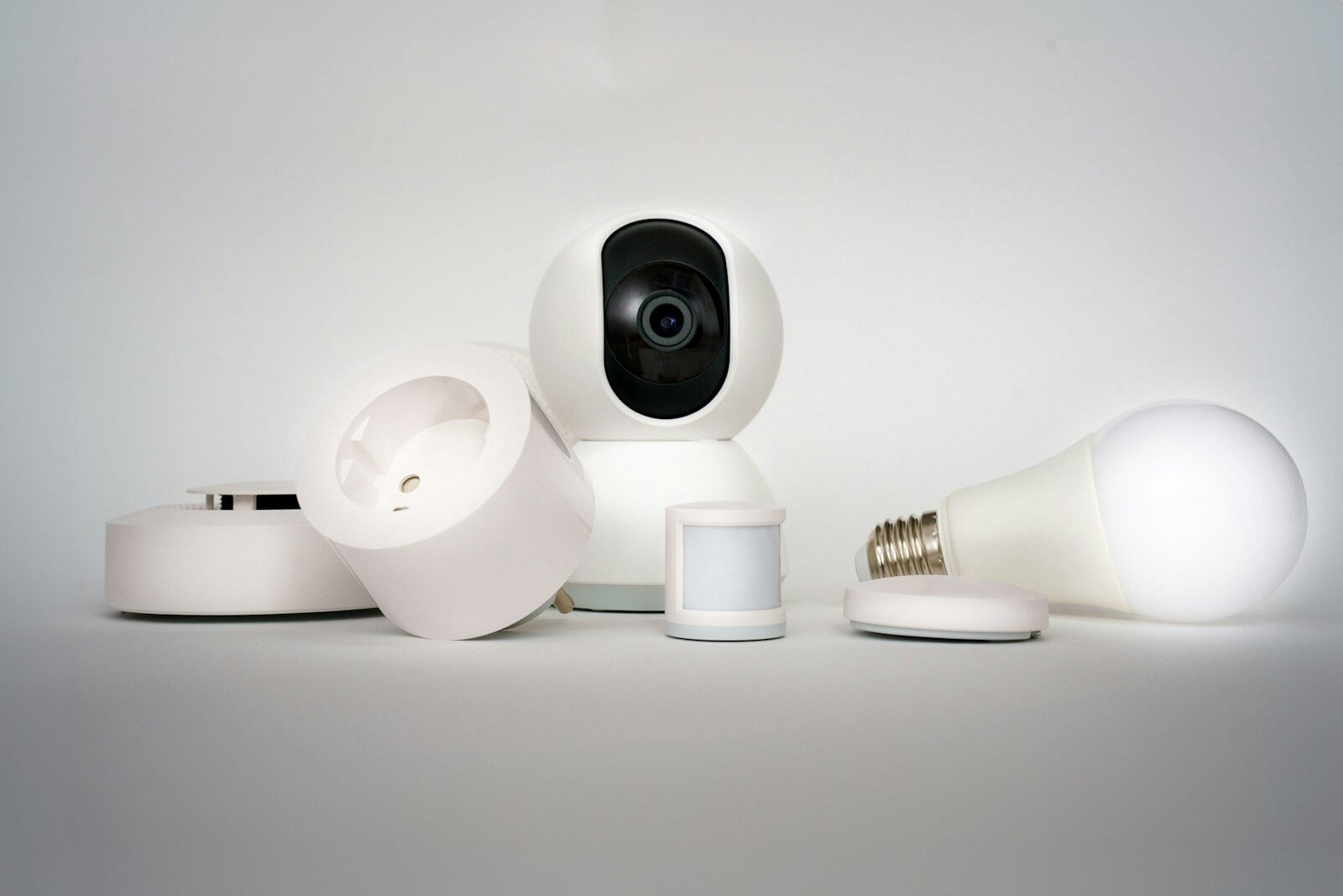 Câmera de segurança inteligente e lâmpadas LED conectadas para automação residencial.