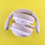 Stylish over-ear headphones in white against a vivid yellow backdrop. Ideal for tech lifestyle imagery.