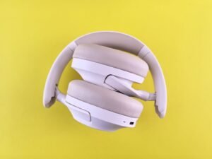Stylish over-ear headphones in white against a vivid yellow backdrop. Ideal for tech lifestyle imagery.